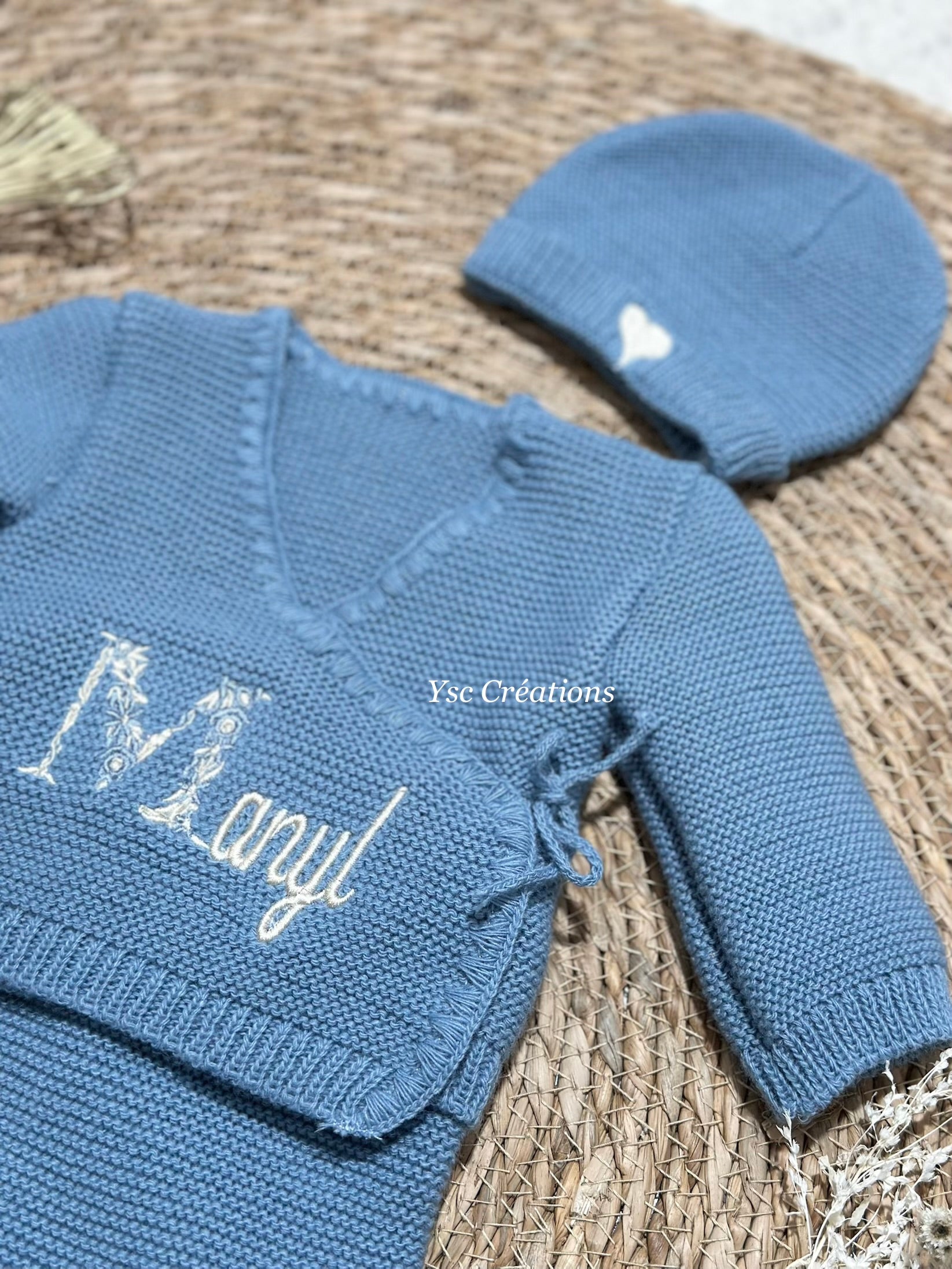 Broderie prénom bébé première lettre fleurie sur gilet de naissance personnalisé